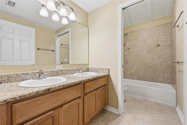 a bathroom with a granite countertop sink a mirror and a bathtub