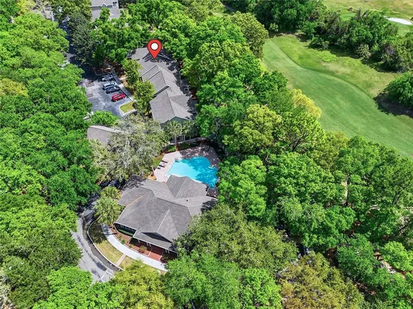 an aerial view of a house with a yard and large trees