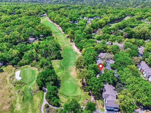 an aerial view of residential house with outdoor space and trees all around