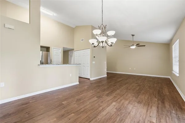 a view of a room with wooden floor and ceiling fan
