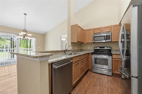 a kitchen with stainless steel appliances granite countertop a stove a sink and a refrigerator