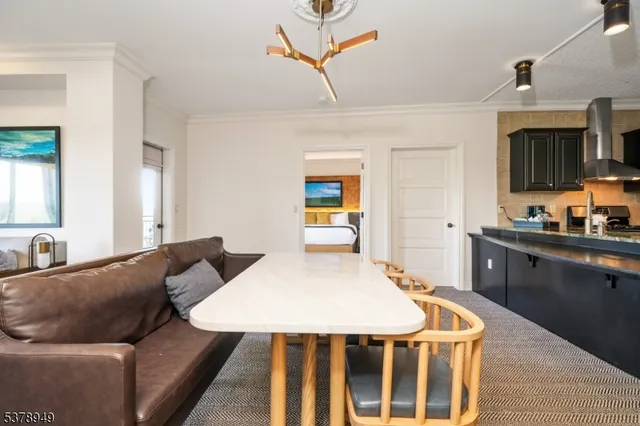 a living room with furniture a flat screen tv and a refrigerator