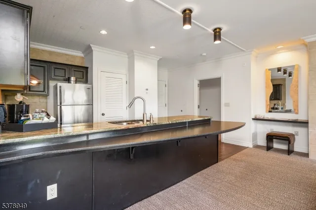a large kitchen with stainless steel appliances a sink and a refrigerator