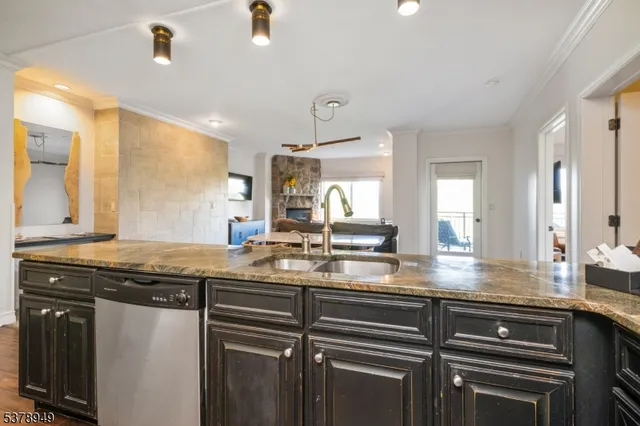 a kitchen with stainless steel appliances granite countertop a sink a stove and cabinets