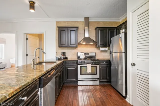 a kitchen with stainless steel appliances granite countertop a sink stove and refrigerator
