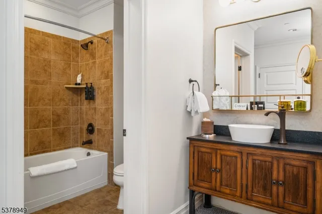 a bathroom with a granite countertop sink a toilet and shower