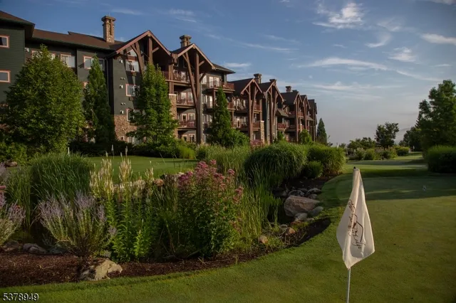 a view of a house with a yard and potted plants