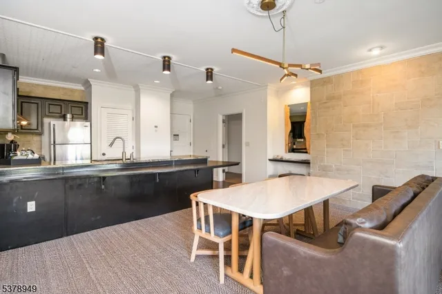 a kitchen with a table chairs sink and wooden floor