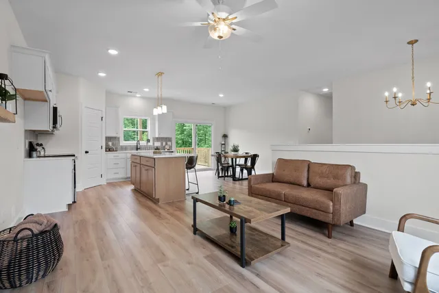 a kitchen with sink a stove and chairs with wooden floor