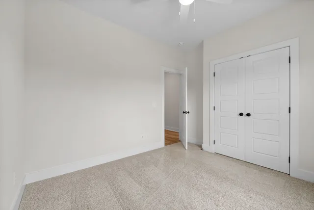 an empty room with a window and a ceiling fan
