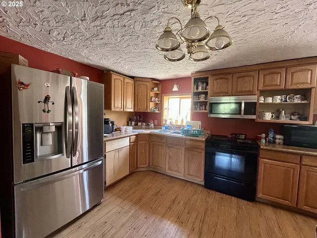 a kitchen with stainless steel appliances granite countertop a refrigerator a stove top oven a sink and dishwasher