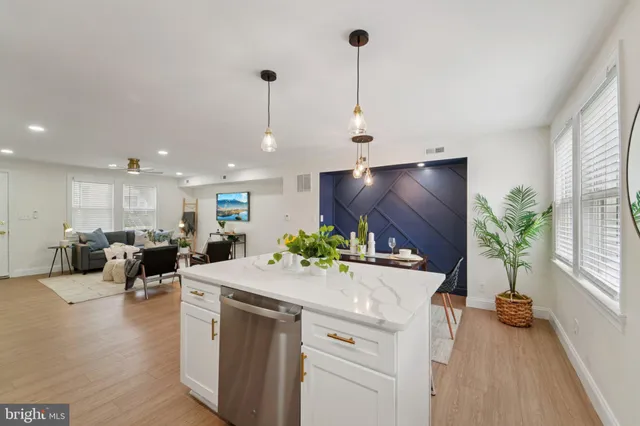 a kitchen with a sink a stove and a wooden floor