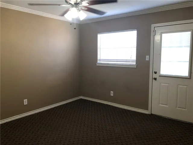 an empty room with a window and a fan
