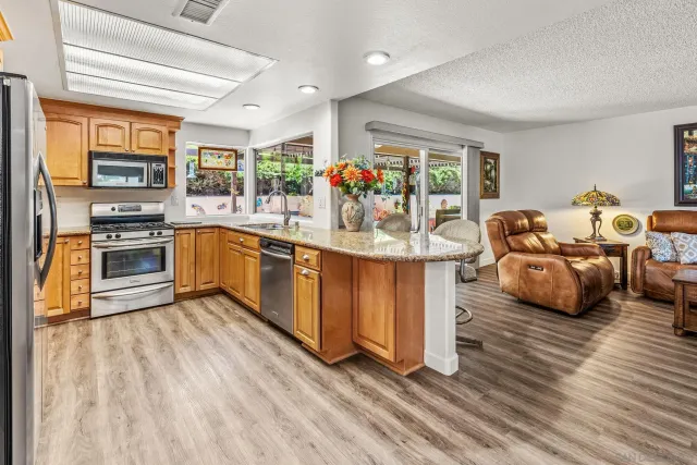 a kitchen with furniture a counter top space and stainless steel appliances
