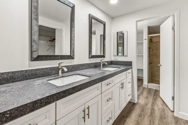 a spacious bathroom with double sink and a mirror