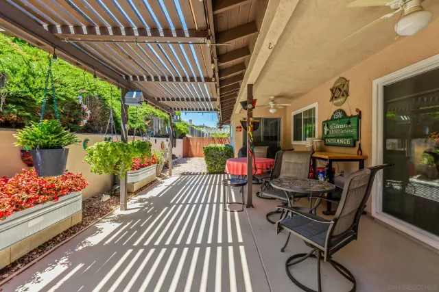 a view of a chairs and tables in patio with potted plants