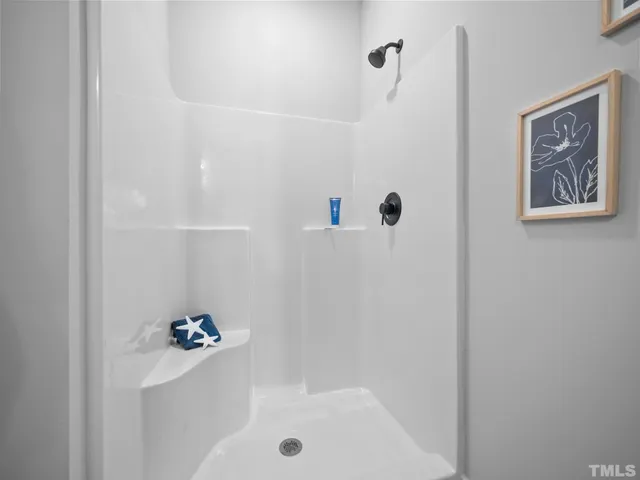 a bathroom with a sink a toilet a mirror and shower