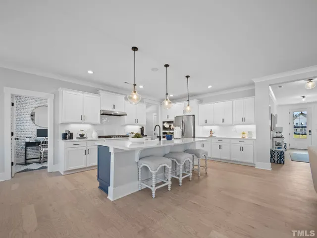 a large white kitchen with a large window and stainless steel appliances