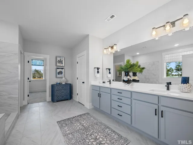 a bathroom with a tub a sink and mirrors