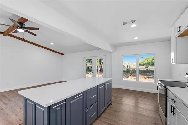 a kitchen with a stove a refrigerator and a dresser with wooden floor