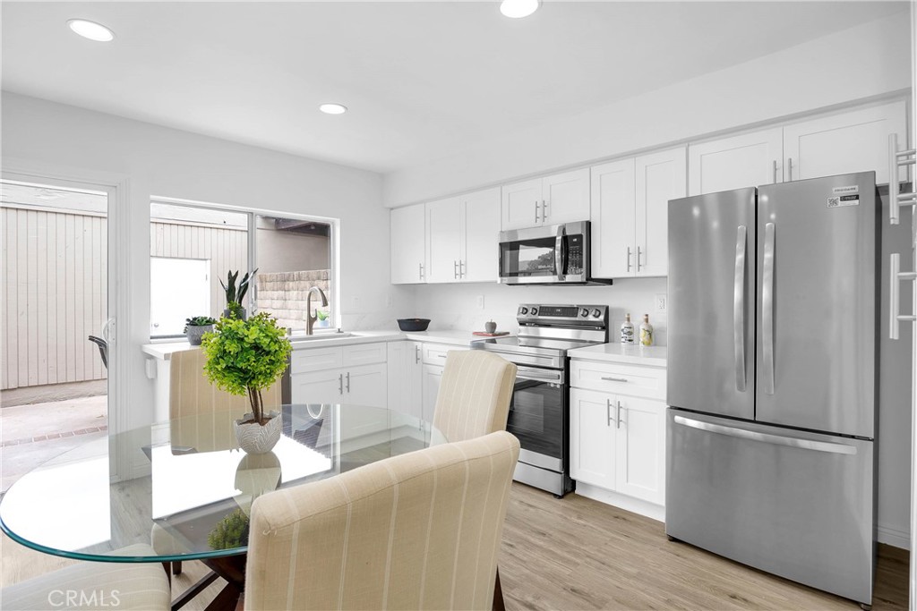 4345 Larwin Avenue Cypress, CA 90630 - Photo 12 of 54 a kitchen with stainless steel appliances a refrigerator a stove a dining table and chairs