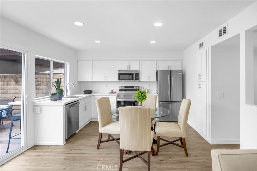 4345 Larwin Avenue Cypress, CA 90630 - Photo 14 of 54 a kitchen with kitchen island white cabinets and stainless steel appliances