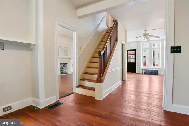 a view of a hallway with wooden floor and staircase