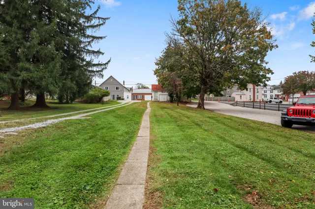 a view of a house with a big yard and large trees
