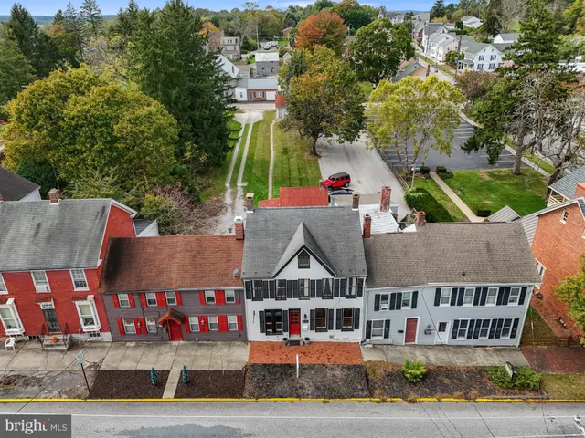 a view of multi story residential apartment building with yard and sign board