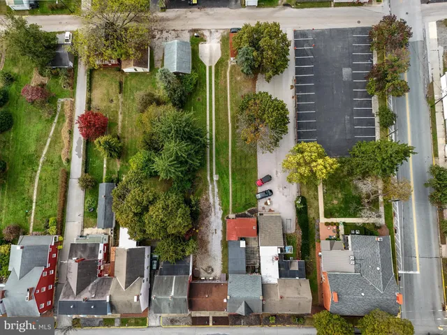 an aerial view of residential houses with outdoor space and parking