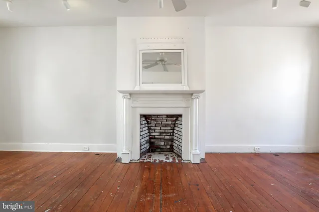 an empty room with windows and fireplace