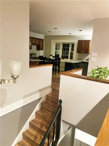 a kitchen with stainless steel appliances granite countertop wooden floor sink stove and refrigerator