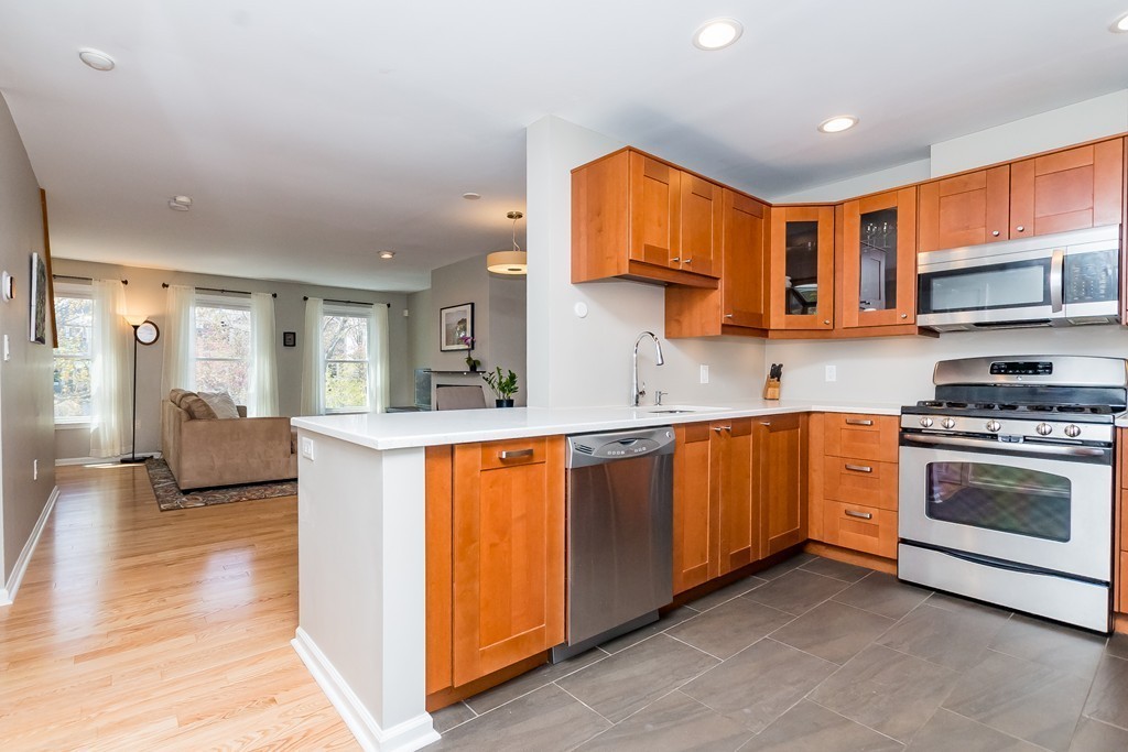 95 Anderer Lane, Unit 4 Boston, MA 02132 - Photo 7 of 22 a kitchen with stainless steel appliances granite countertop a stove a sink and a refrigerator