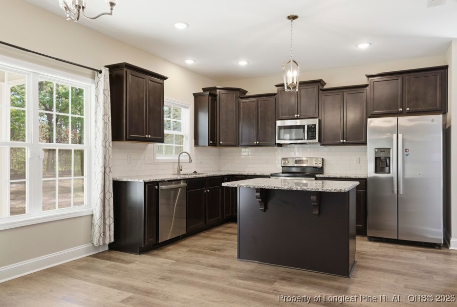 4830 Quiet Pine Road Fayetteville, NC 28314 - Photo 12 of 50 a large kitchen with stainless steel appliances granite countertop a stove a sink dishwasher a refrigerator and a microwave oven with wooden floor