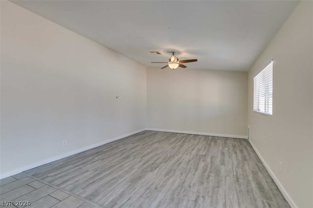 2028 Rustler Ridge Avenue North Las Vegas, NV 89031 - Photo 8 of 40 A versatile living space featuring resilient flooring and a ceiling fan for year-round comfort.