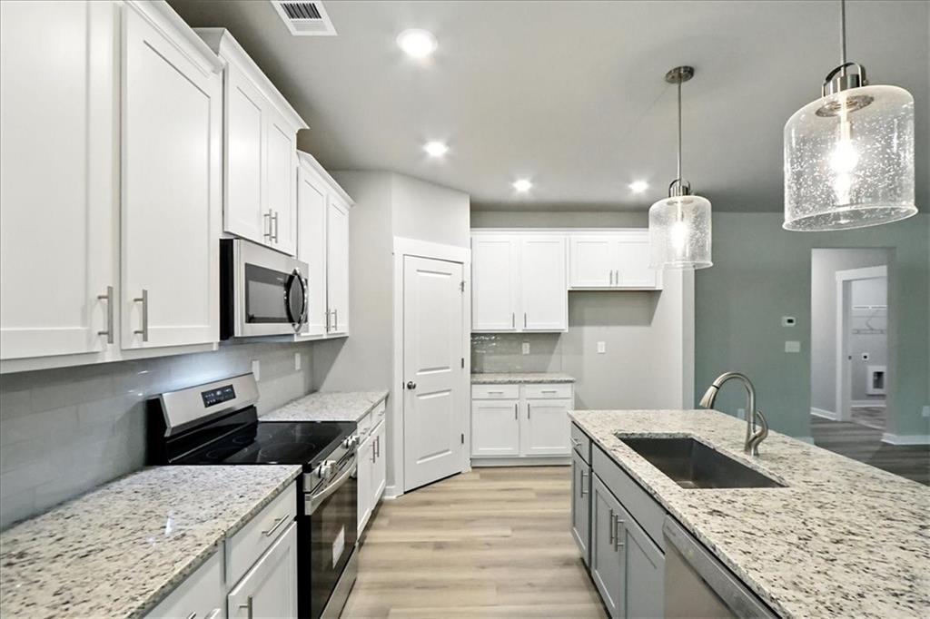 4022 Links Boulevard Jefferson, GA 30549 - Photo 12 of 54 a kitchen with stainless steel appliances granite countertop a sink stove and refrigerator