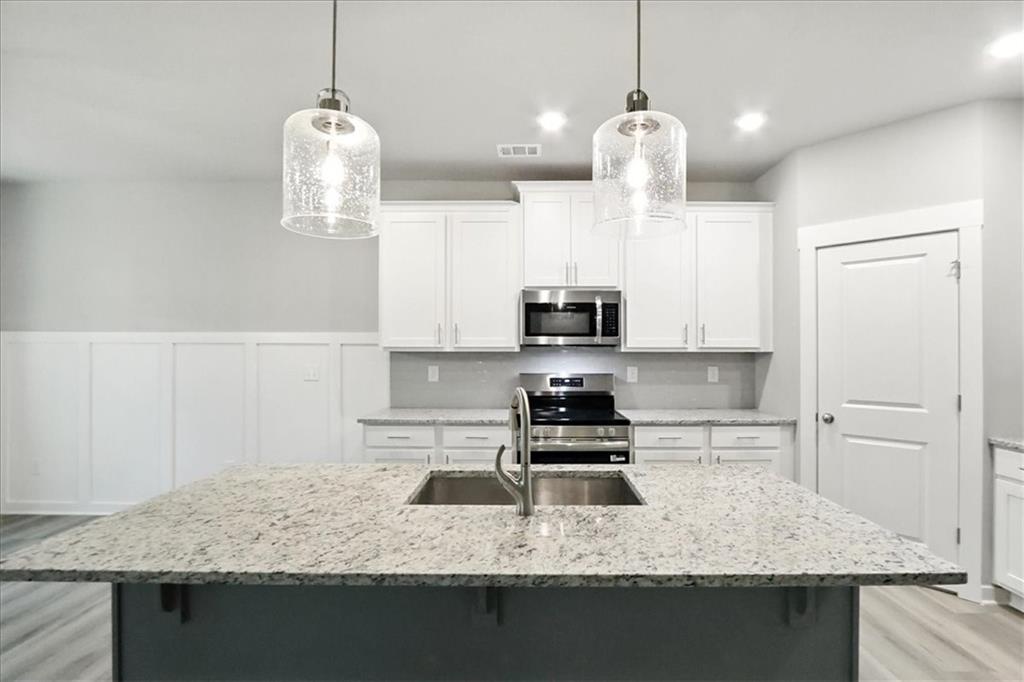 4022 Links Boulevard Jefferson, GA 30549 - Photo 13 of 54 a kitchen with kitchen island granite countertop a counter space windows and a ceiling fan