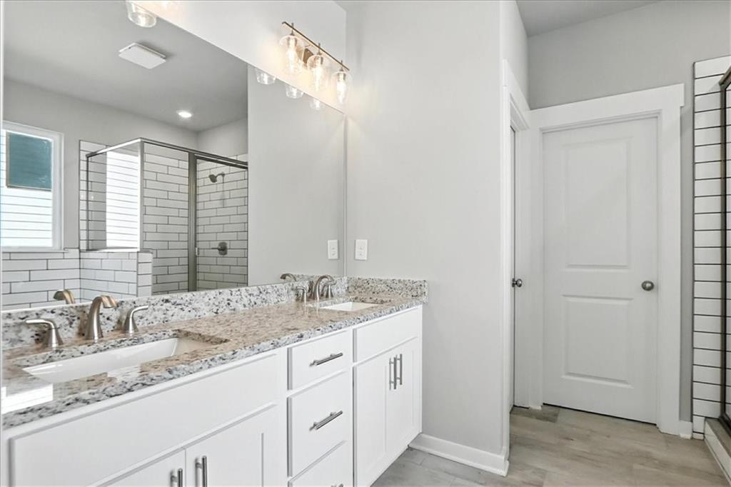 4022 Links Boulevard Jefferson, GA 30549 - Photo 29 of 54 a bathroom with a granite countertop sink and a mirror