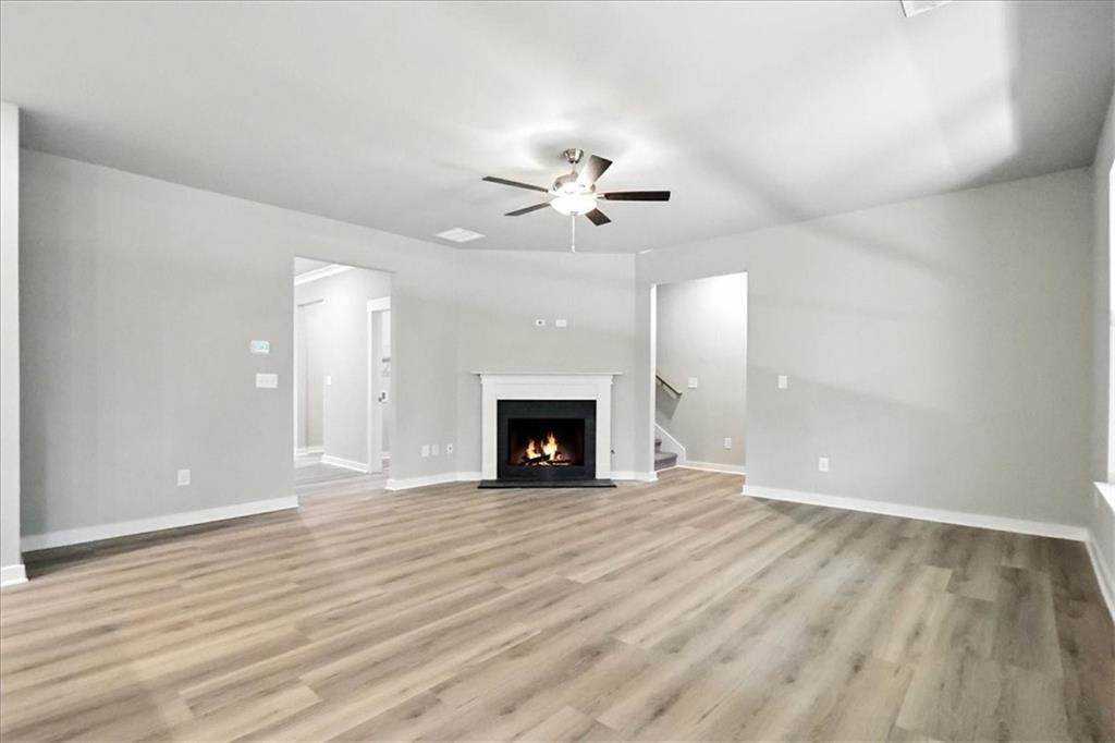 4022 Links Boulevard Jefferson, GA 30549 - Photo 6 of 54 a view of an empty room with a fireplace and a chandelier fan