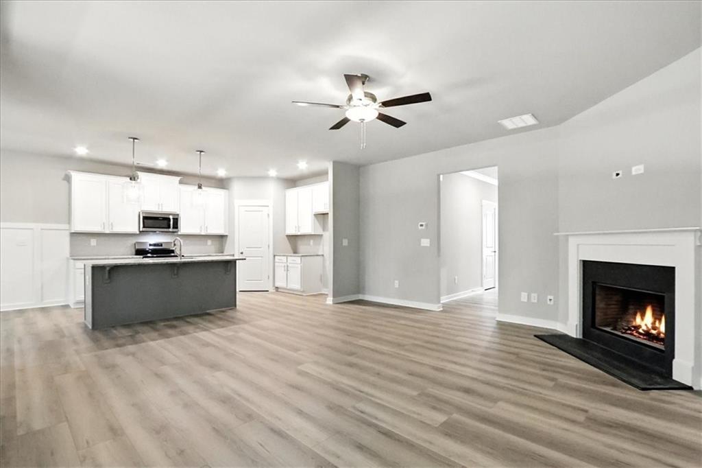 4022 Links Boulevard Jefferson, GA 30549 - Photo 8 of 54 a large kitchen with kitchen island a sink wooden floor and a living room