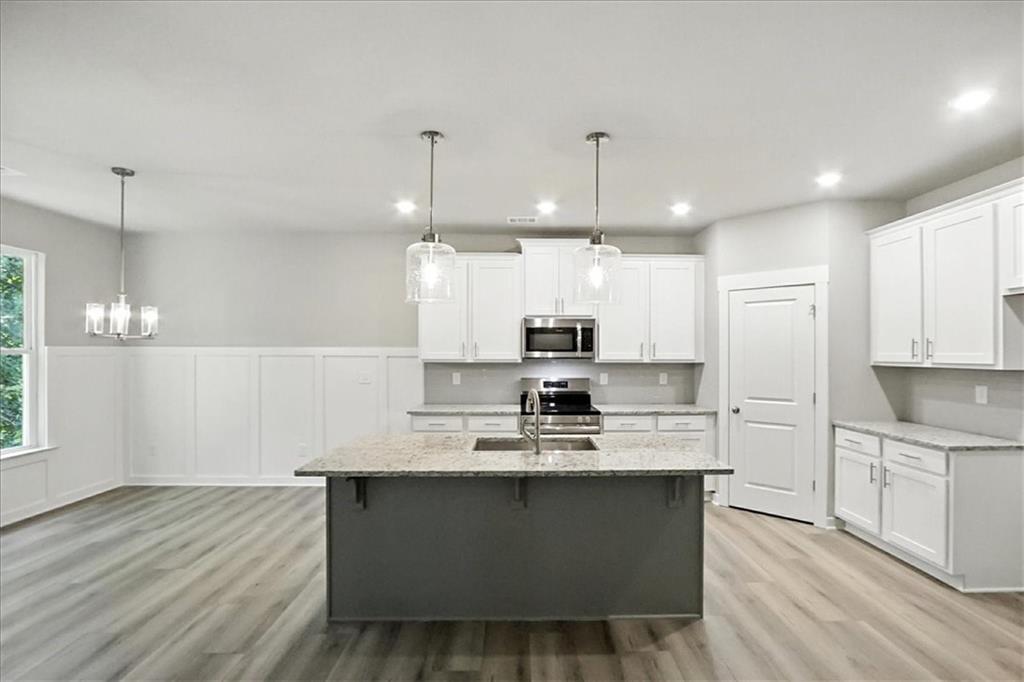 4022 Links Boulevard Jefferson, GA 30549 - Photo 9 of 54 a large kitchen with kitchen island a sink a center island stainless steel appliances and a window