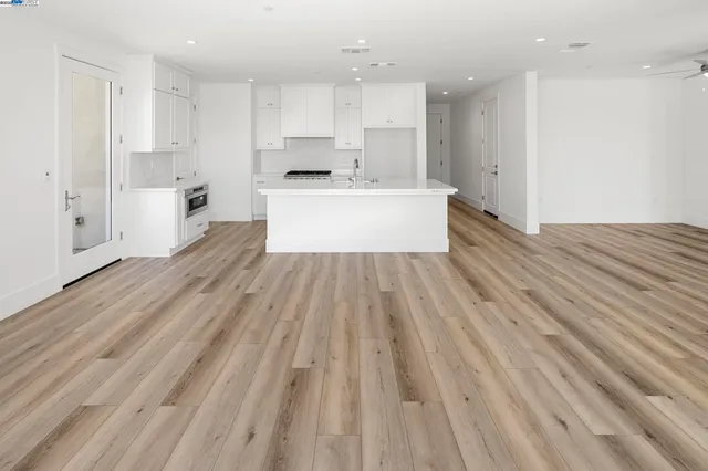 a view of a kitchen with wooden floor and windows