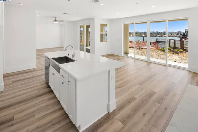 a open kitchen with a sink and wooden floor