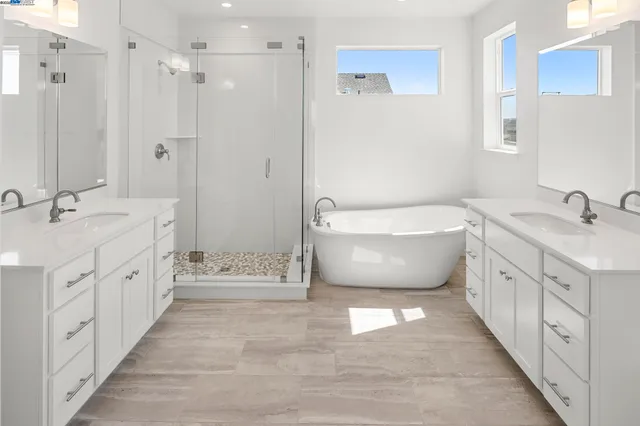 a spacious bathroom with a double vanity sink a large mirror and a bathtub