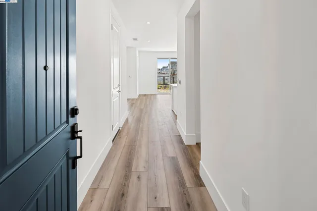 a view of a hallway with wooden floor and staircase