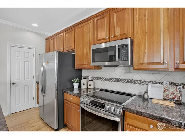 a kitchen with stainless steel appliances granite countertop a refrigerator stove and microwave