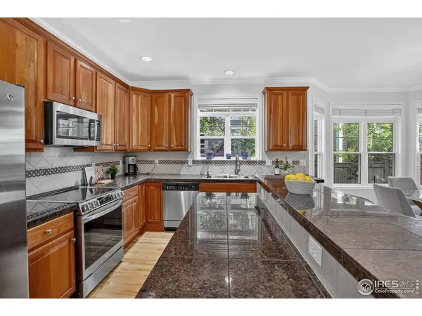 a kitchen with stainless steel appliances granite countertop sink stove top oven and cabinets