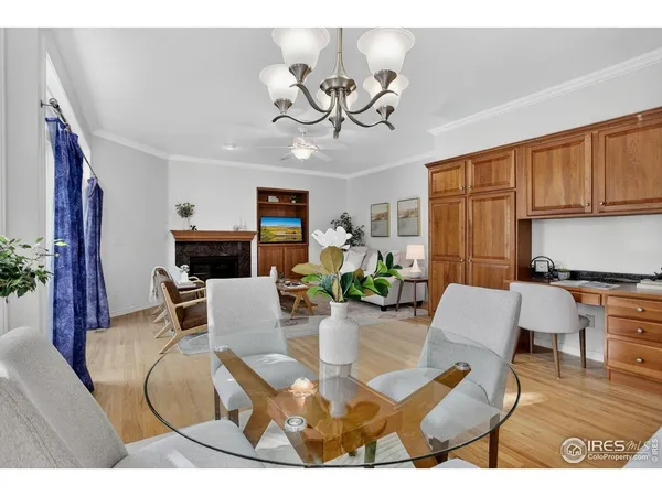 a living room with furniture a chandelier and a dining table with wooden floor