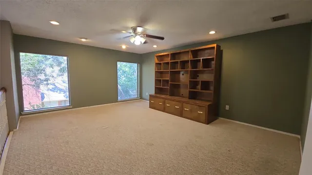 a view of an empty room with a window and chandelier