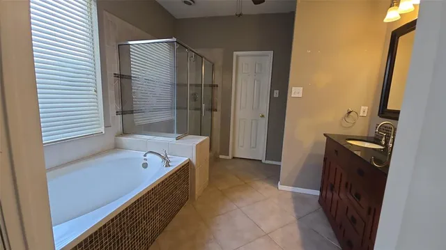 a bathroom with a tub sink and mirror